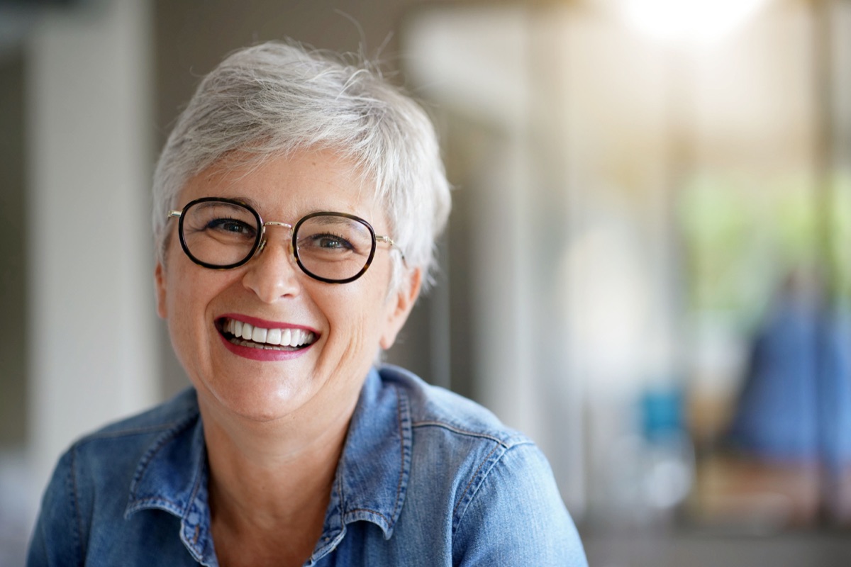 Woman smiling, wearing stylish glasses