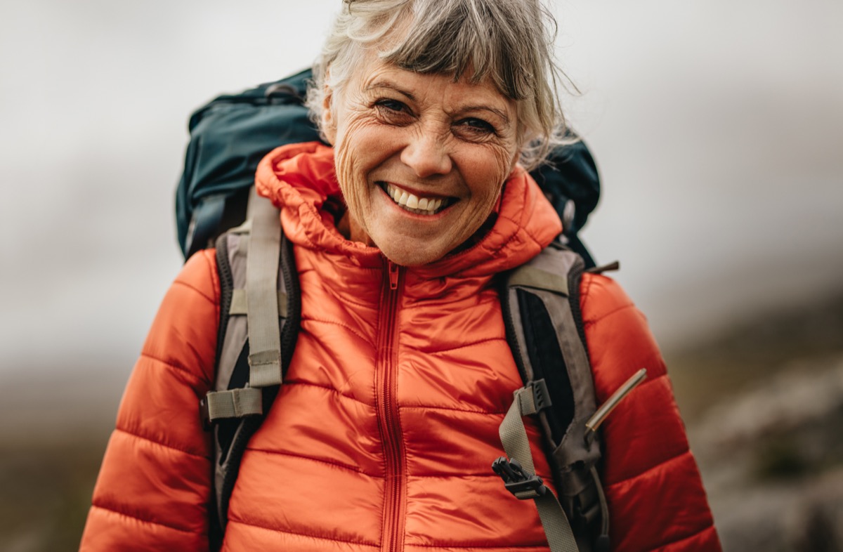 Active woman hiking outdoors, smiling